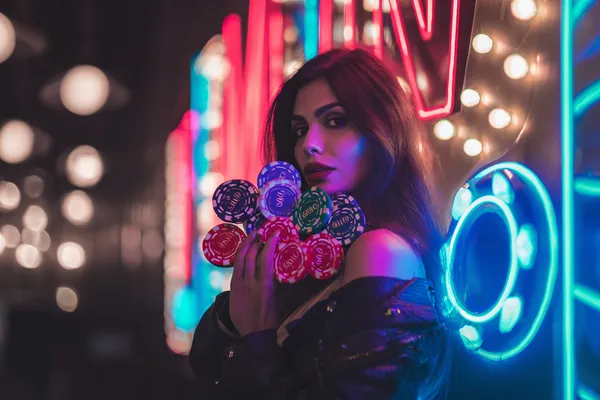 A glamorous woman holding casino chips in a neon-lit environment, representing the premium online casino atmosphere of WA777PK.